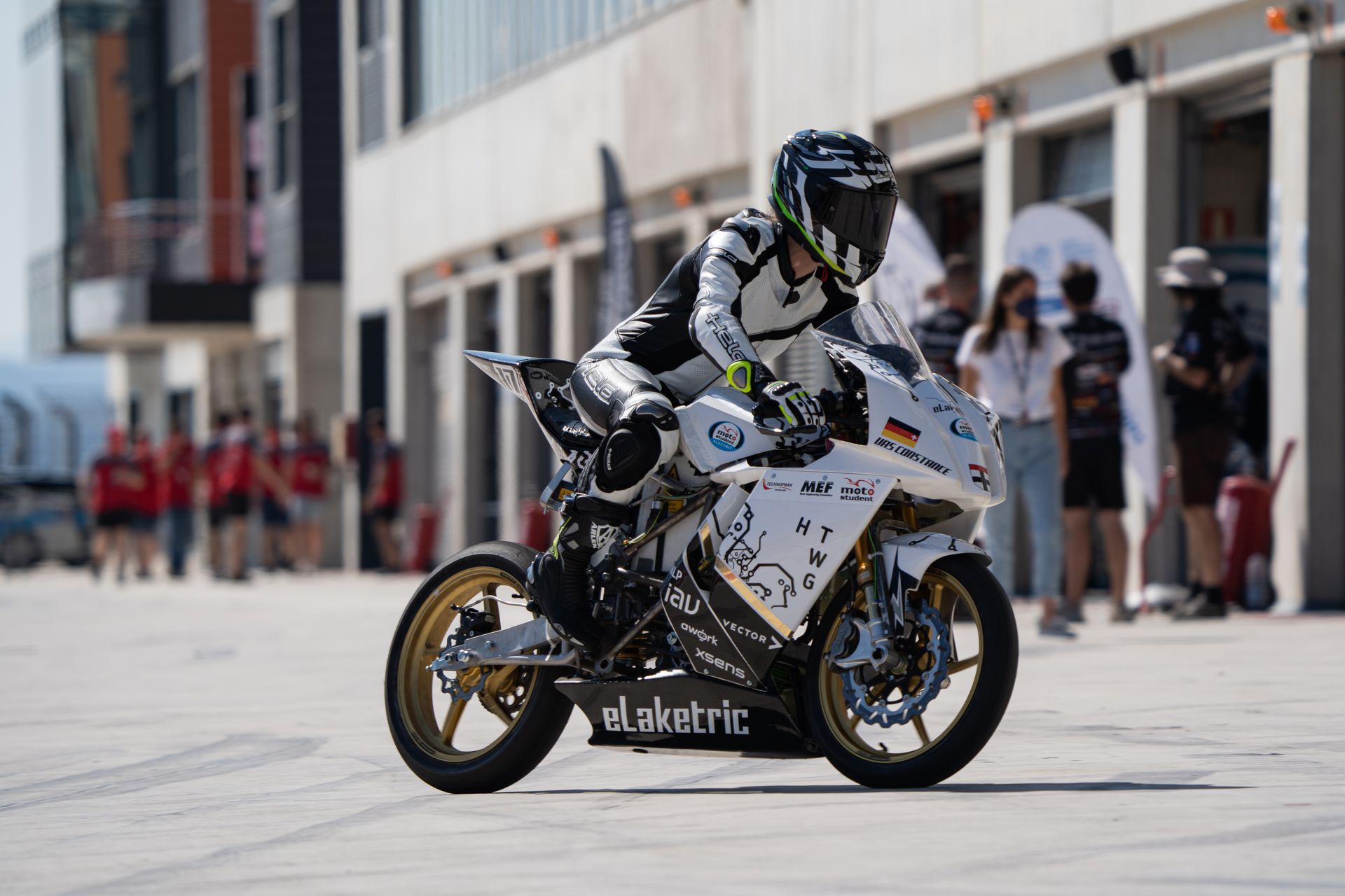 Eine Rennfahrerin auf einem Motorrad in der Boxengasse.