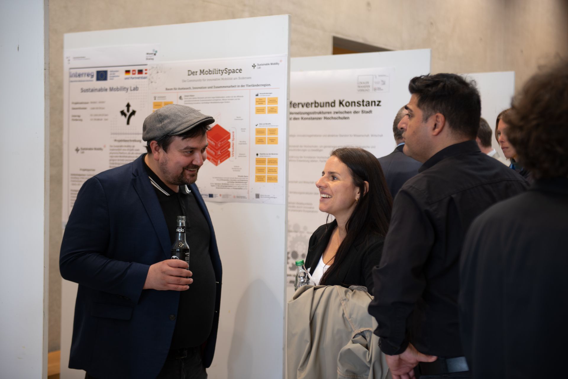 Bei der Posterausstellung unterhalten sich zwei Teilnehmende.