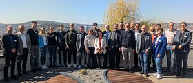 Eine Gruppe Menschen steht zusammen und lächelt in die Kamera