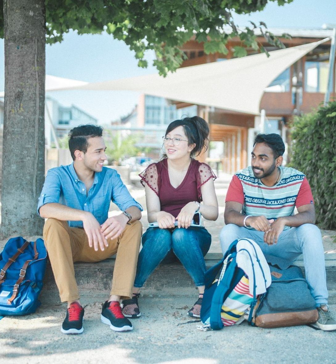 Studierende sitzen an der Standbar und unterhalten sich