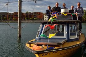 Fünf Männer posieren auf einem Boot mit bunten Fähnchen fürs Foto. Es ankert am Seerheinufer vor der HTWG.