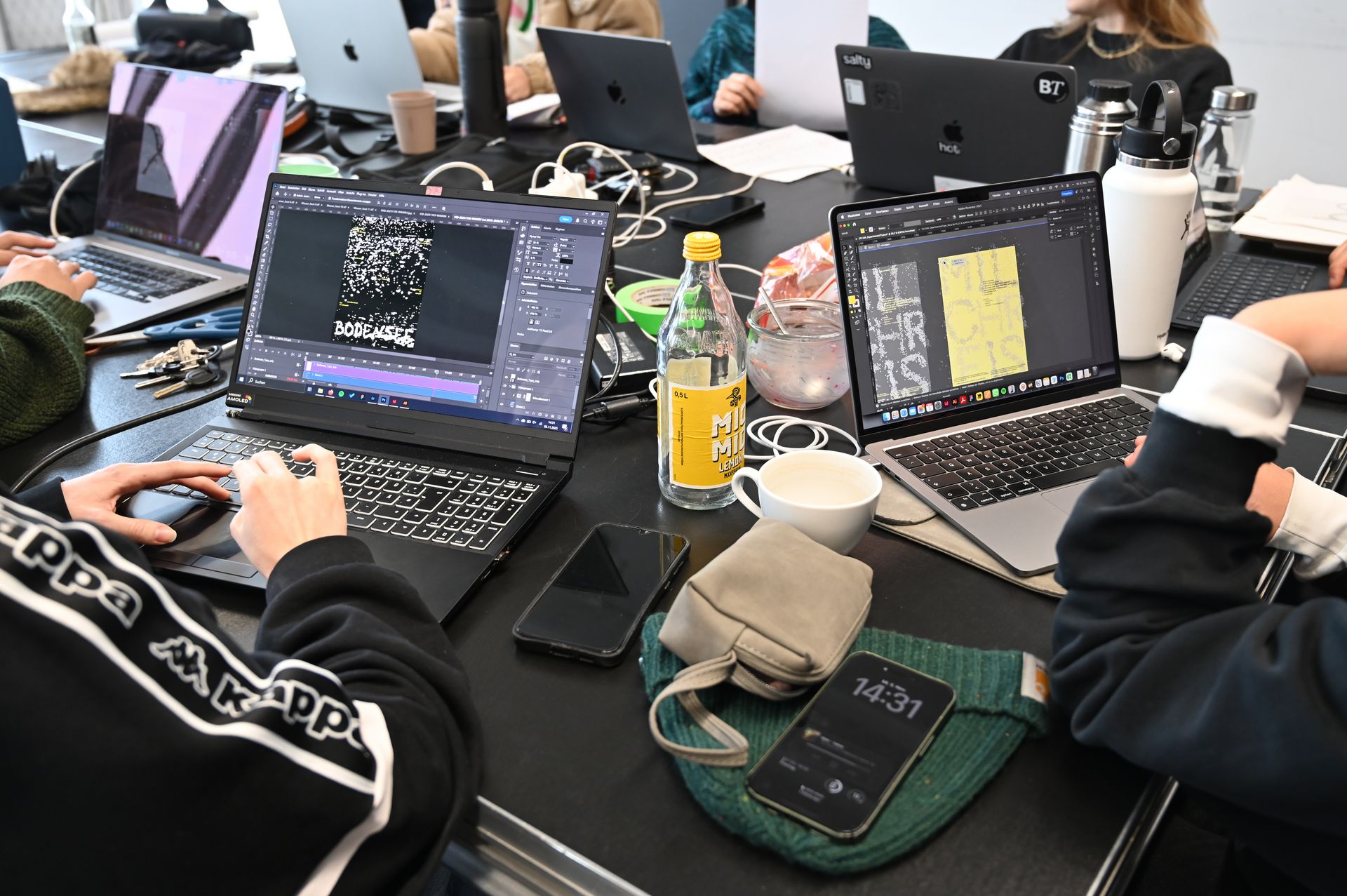 Blick auf einen Arbeitstisch mit Rechnern, Utensilien etc.