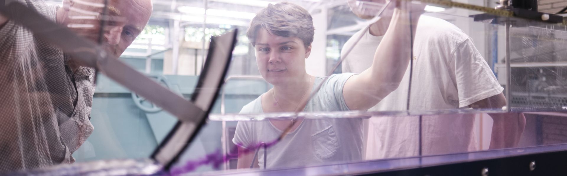 Eine Studentin spritzt Farbe in eine Strömungsrinne um das Strömungsverhalten zu prüfen. Eine Studentin spritzt Farbe in eine Strömungsrinne um das Strömungsverhalten zu prüfen.