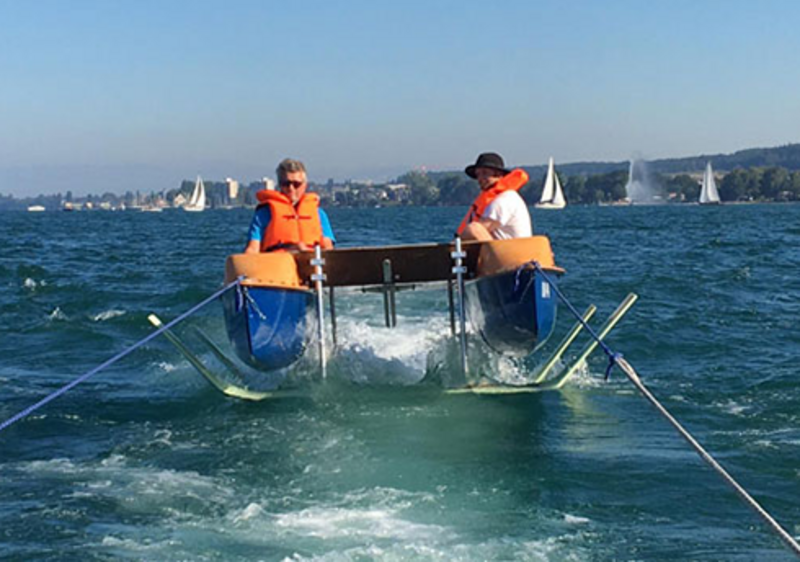 Tragflügelboot mit 2 Studierenden in orangefarbenen Schwimmwesten auf dem Bodensee