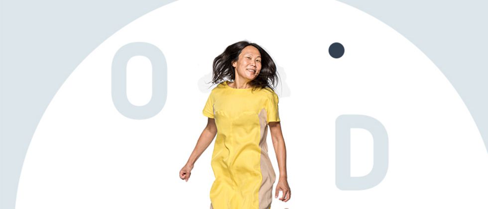Eine Frau in einem gelben Kleid springt in die Luft.