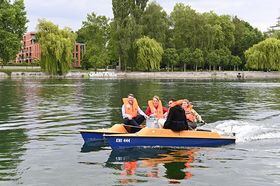 Vier Personen fahren auf einem Solarboot auf dem Seerhein in Konstanz
