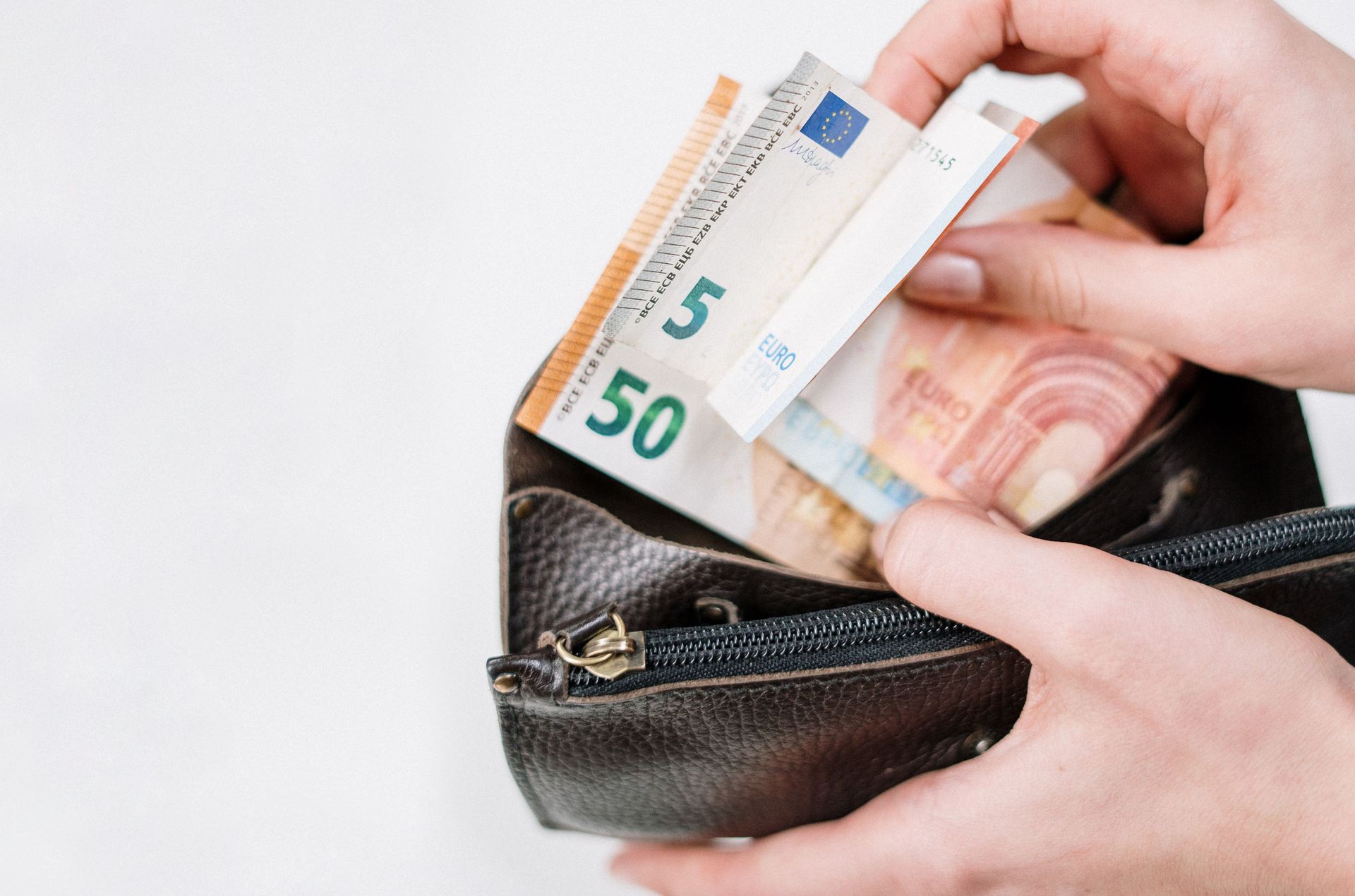 Person removing Euro bills from a wallet.