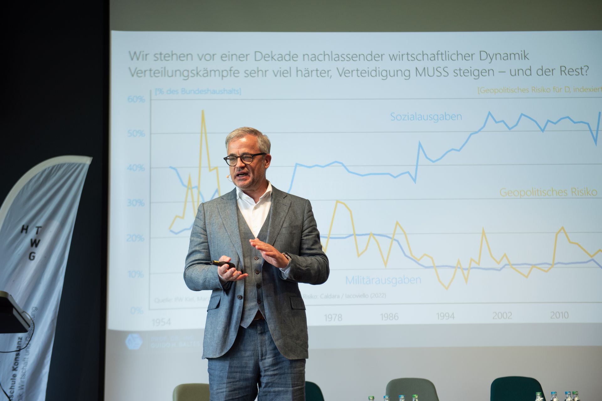 Prof. Dr. Guido Baltes steht auf der Bühne und hält eine Keynote.