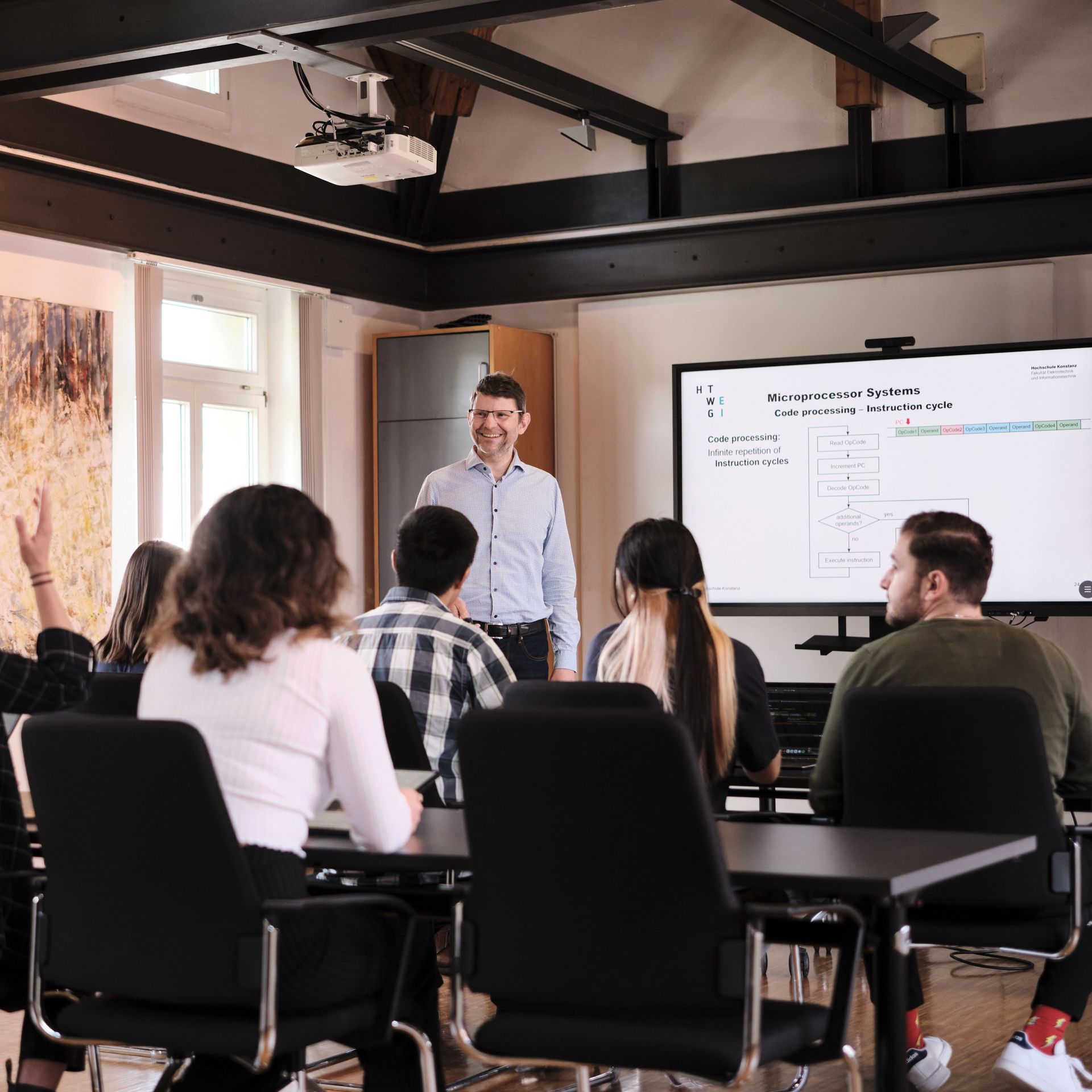 Professor steht im Klassenraum vor den Kursteilnehmer*innen