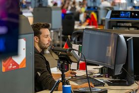 Ein junger Mann sitzt an einem Computer und arbeitet konzentriert