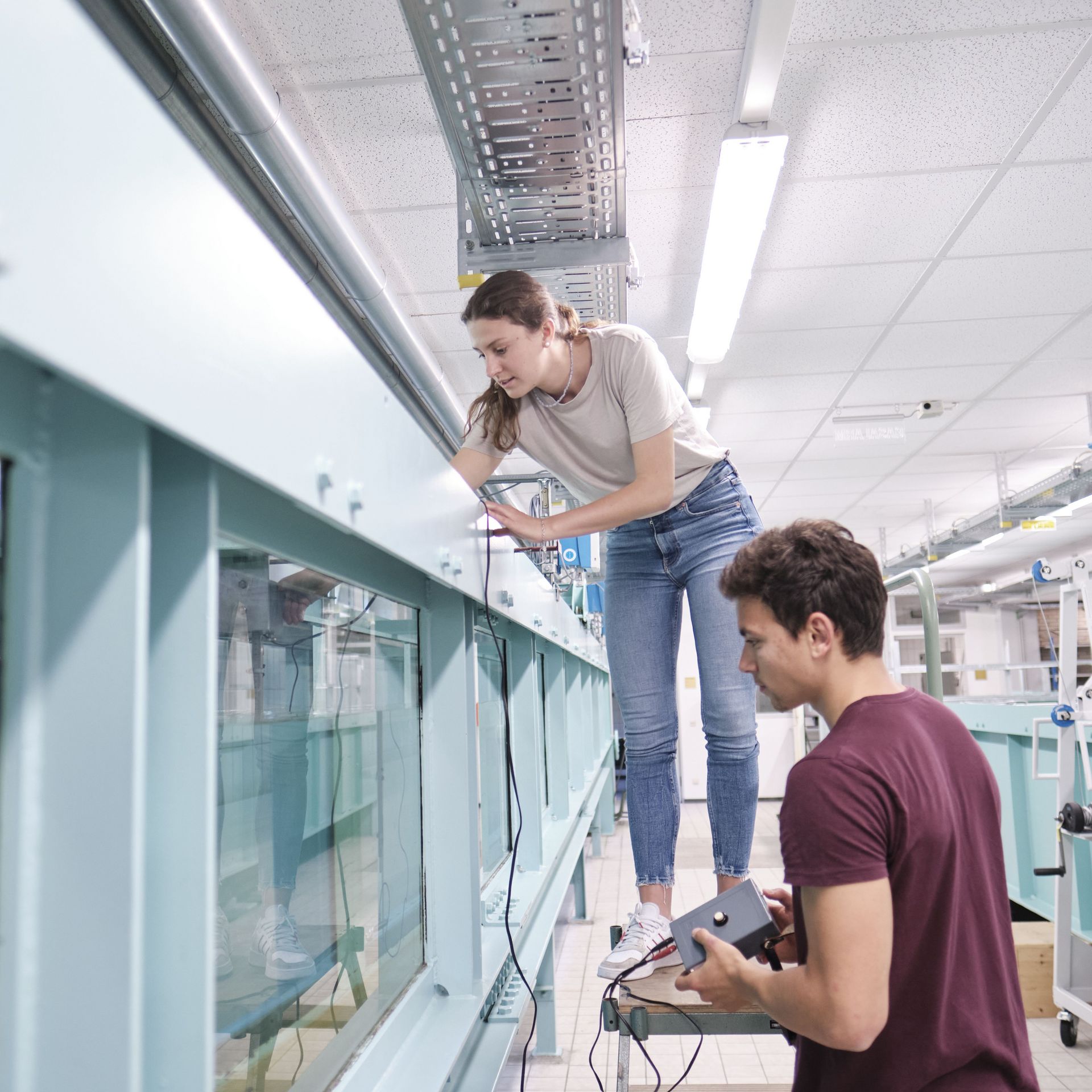 Studierende führen Experiment am Kanal im Wasserbaulabor durch
