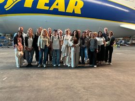 Eine Gruppe von rund 30 Personen steht vor einem Zeppelin