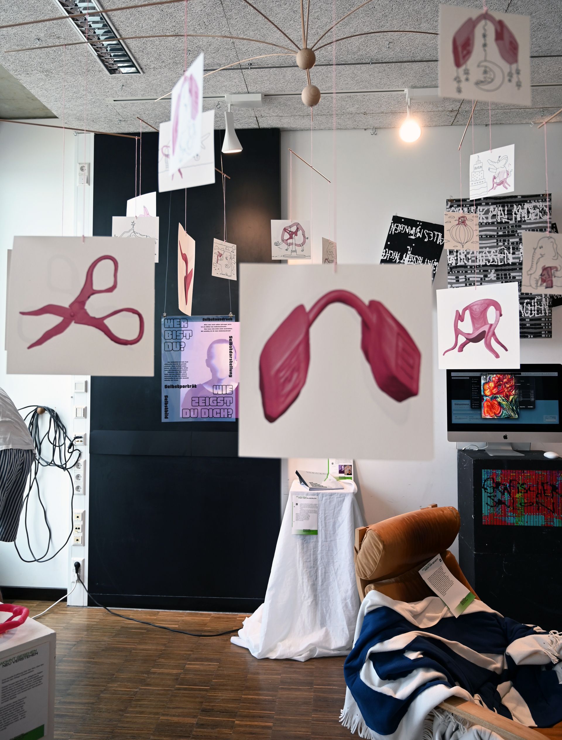 Blick in Ausstellungsraum "Grafischer Salon" mit von der Decke hängenden Postkarten