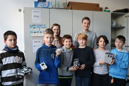 Schüler des Humboldt Gymnasiums Konstanz stehen mit zwei Studierenden der fakultät EI zusammen und zeigen ihre selbst genauten Exponate der Lego Mindstorms AG.
