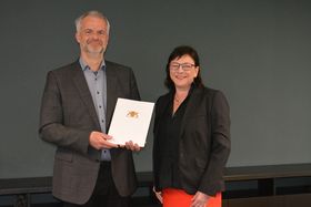 Gruppenfoto: Kanzler Manfred Schnell hält die Ernennungskurkunde vor sich, neben ihm steht HTWG-Präsidentin Prof. Dr. Sabine Rein. 