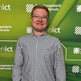 Ein junger Mann steht vor einem grünen Werbehintergrund