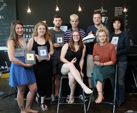 Acht Studierende posieren im Café Endlicht fürs Foto.