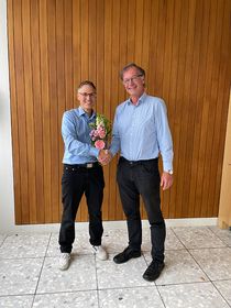 Thomas Birkhölzer überreicht Marcus Kurth einen Blumenstrauß und schüttelt ihm die Hand