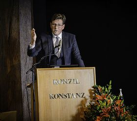 HTWG-Präsident Prof. Dr. Carsten Manz steht am Rednerpult und unterstreicht seine Rede mit einer Geste, indem er die rechte Hand hebt.