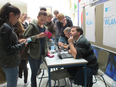 Wie komme ich ins WLAN ? Zwei Mitarbeiter des Rechenzentrums beraten Studierende.