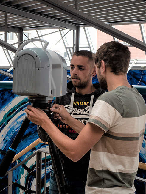 Studierende arbeiten in einem Treppenhaus mit einem 3D-Laserscanner