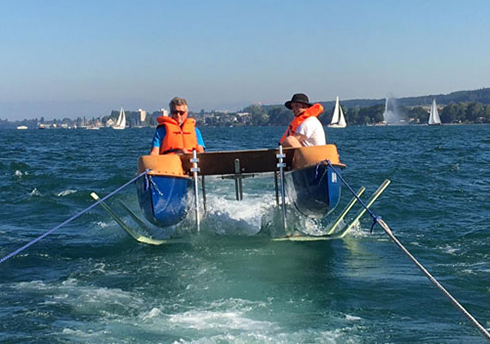 Tragflügelboot mit 2 Studierenden in orangefarbenen Schwimmwesten auf dem Bodensee