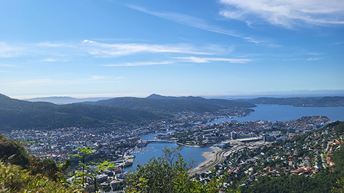 Blick von oben auf eine Stadt mit Wasser, blauer Himmel