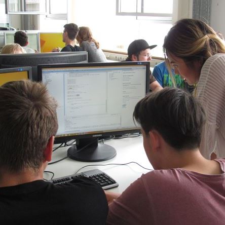junge Menschen in einem PC-Pool vor Bildschirmen