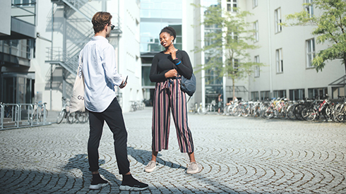 Two people are talking to each other on campus.