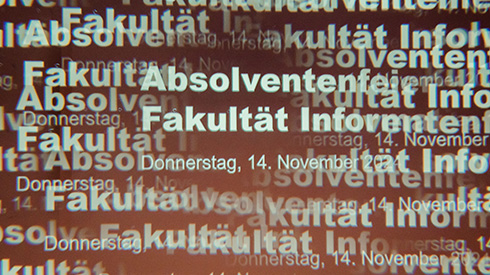 Text "Absolventenfeier Fakultät Informatik " der gedoppelt und ineinanderfließend eingeblendet wird, die Schriftfarbe ist weiß, der Hintergrund braun.