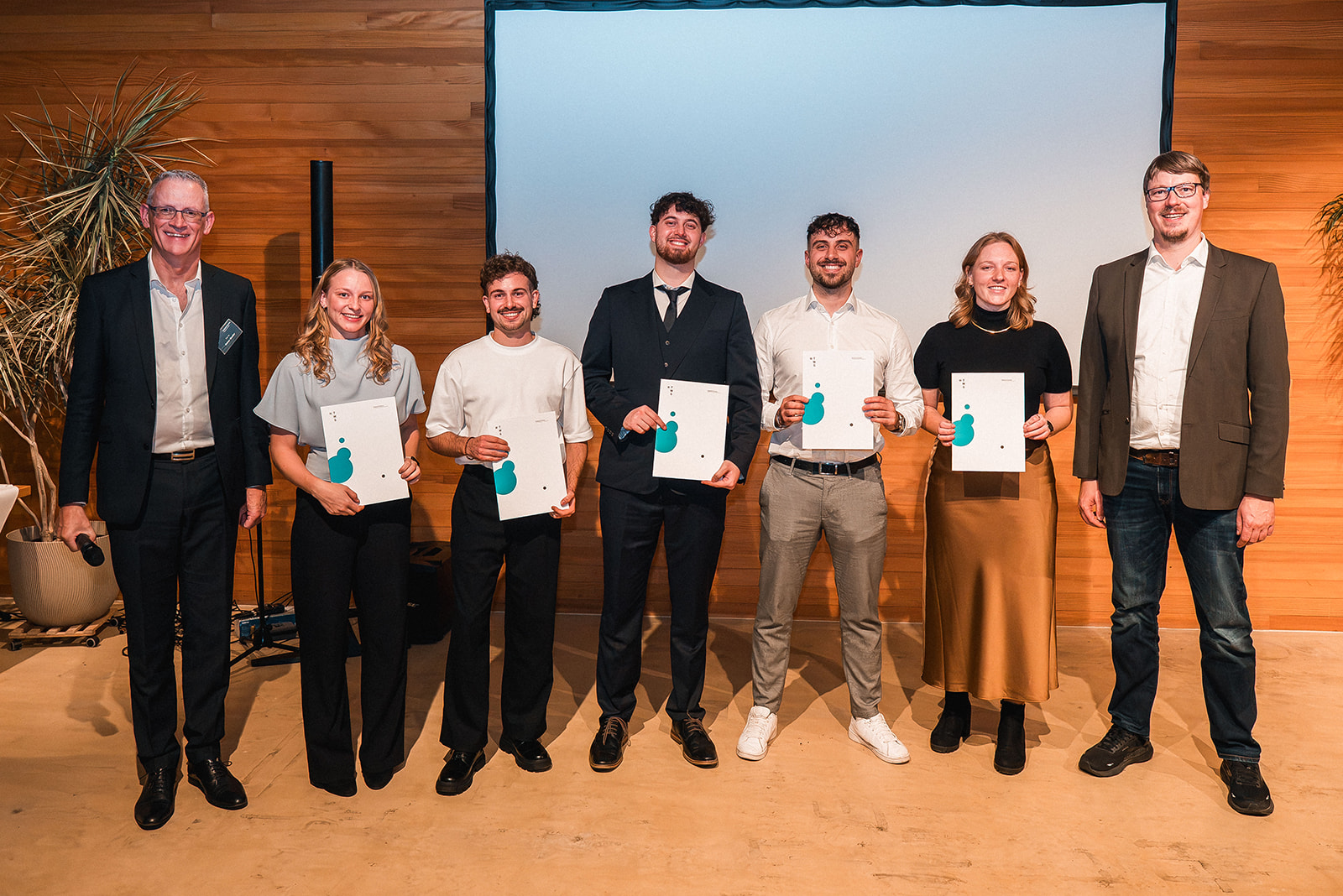 Personengruppe, von denen einige eine Dokumentenmappe vor sich halten