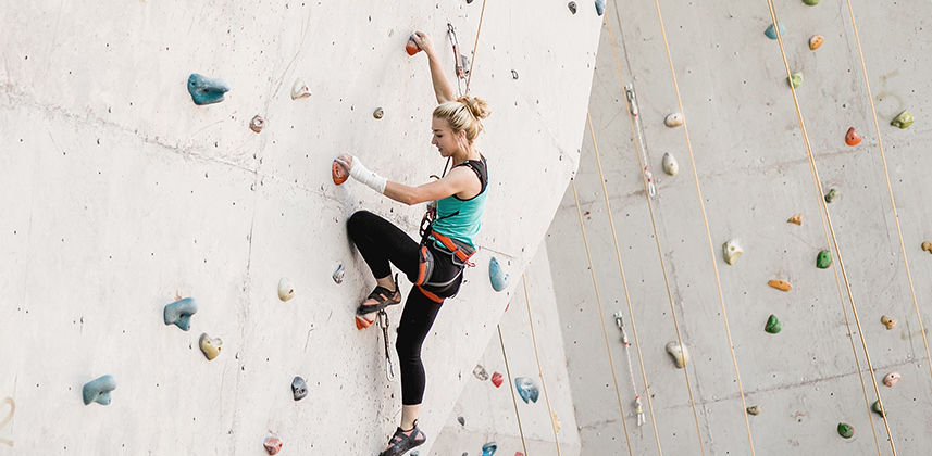 Eine Frau beim Klettern in der Kletterhalle