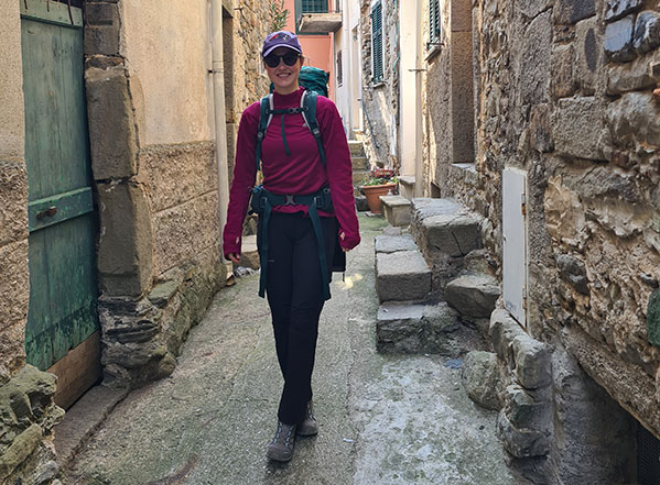 Junge Frau in Wanderkleidung in einer engen Gasse