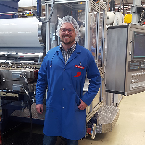 Bild von Maschinenbau Absolvent Adrian Schilling in blauem Kittel Bild von Maschinenbau Absolvent Adrian Schilling in blauem Kittel