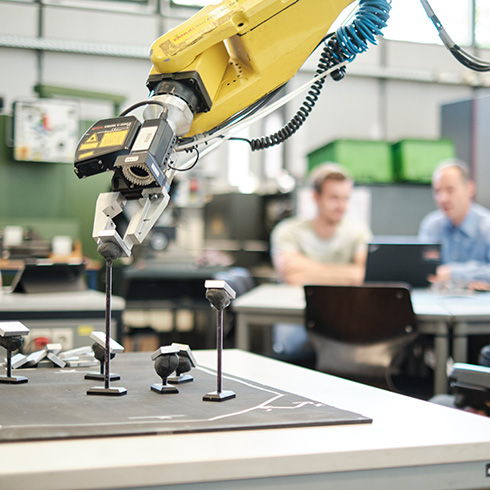 Praxisprojekt im Maschinenbau Studium: Prof und Student beobachten Roboter mit Schunk Greifer