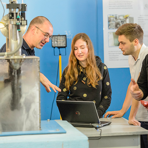 Maschinenbau Studium: Prof erklärt Studierenden Versuch im Strömungslabor