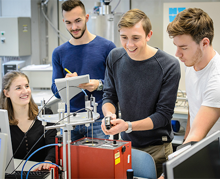 Vier Studierende an einer Messstation im Physiklabor