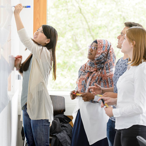 Group of international students writing on the whiteboard