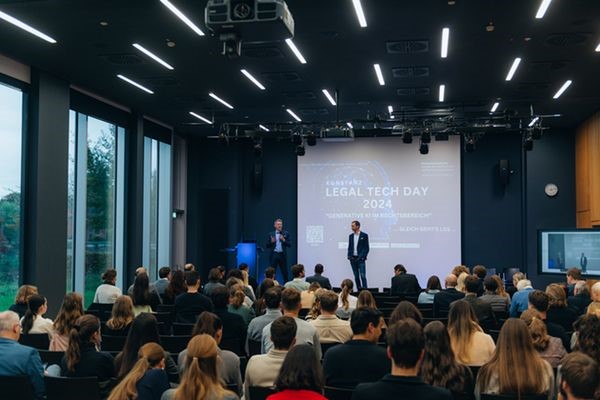 Blick über das volle Plenum auf die Bühne mit den beiden Veranstaltern