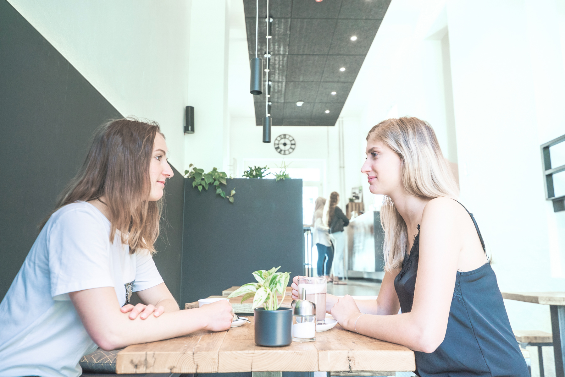 2 Studierende sitzen ins Gespräch vertieft im Café