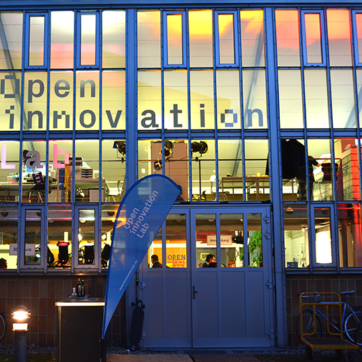 Fensterfront des Open Innovation Labs mit farbigem Licht