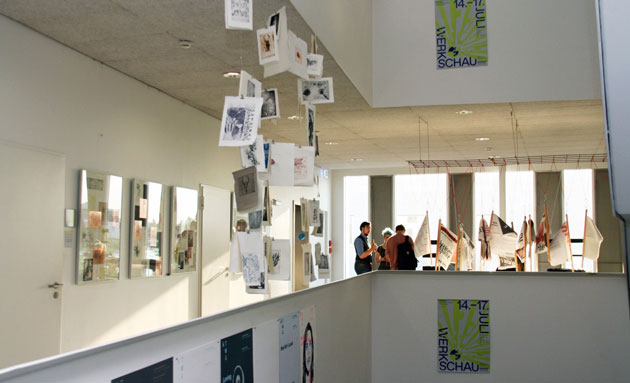 Das Atrium des Gebäudes der Kommunikationsdesigner an der HTWG: An den Wänden und von der Decke hängen Bilder.