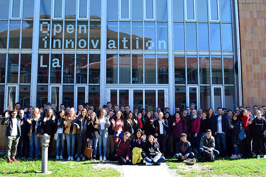 Eine große Gruppe junger Menschen steht vor dem Open Innovation Lab auf dem HTWG Campus und posiert fürs Foto.