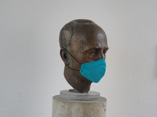 Büste des Hochschulgründers Alfred Wachtel mit einer grünen Stoffmaske.