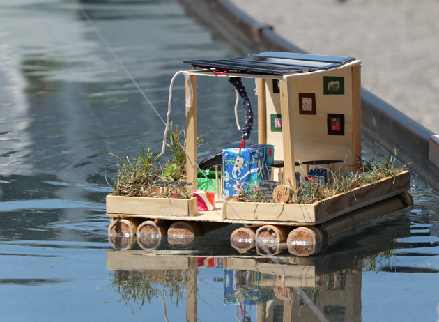 Ein Solarmodellboot aus Holz und Bambus schwimmt auf Wasser.