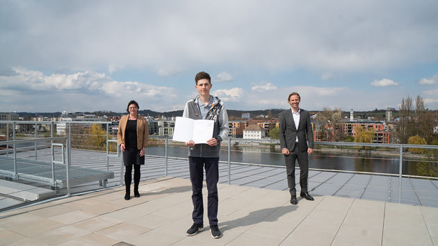 Auf einer Dachterrasse stehen Preisträger Tobias Neidhart mit Urkunde, links von ihm Präsidentin Prof. Dr. Sabine Rein, rechts von ihm Prof. Dr. Gunnar Schubert, Vizepräsident für Forschung, Transfer und Nachhaltigkeit..