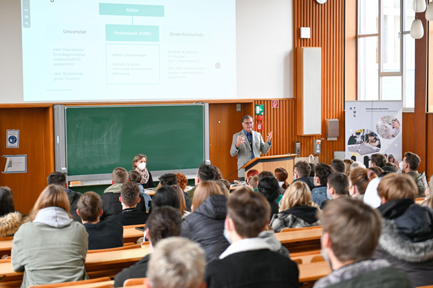 Blick in einen Vorlesungssaal von hinten über Schüler nach vorne auf den Redner Prof. Thomas Birkhölzer. 