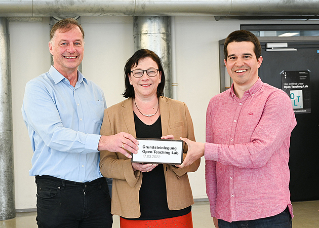 Drei Personen halten einen symbolischen Grundstein vor der Brust, auf dem steht "Grundsteinlegung Open Teaching Lab 17.03.2022". Sie legten den Grundstein für das Open Teachin Lab (OTL) an der HTWG (von links): Prof. Dr. Thomas Birkhölzer, Vizepräsident Lehre, Qualität und digitale Transformation, HTWG-Präsidentin Prof. Dr. Sabine Rein und Mihai Ganea, Leiter des Open Teaching Labs.