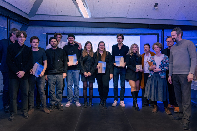 Gruppenfoto mit jungen Menschen auf einer blau ausgeleuchteten Bühne.