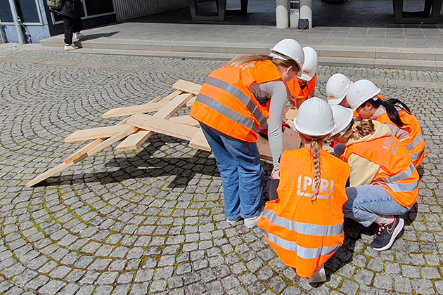 Sechs Schülerinnen bauen beim Mädchen-Zukunftstag an der HTWG eine Leonardo-Brücke auf dem Hof.